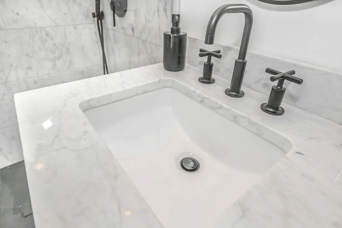 Brushed metal faucet over a white undermount sink